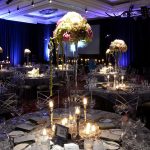 Candlelit round tables with tall floral centerpieces