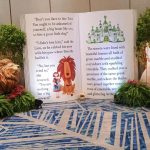 Oversized storybook backdrop with a lion statue and Emerald City signs