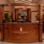 Round wooden wine bar with shelving and plants