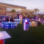 Evening lawn event with glowing cocktail tables and string lights