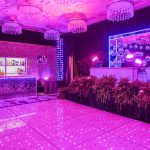 Magenta LED dance floor with pink uplighting and a lit bar