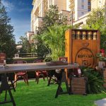 Lawn lounge with a whiskey and cigar crate display and plants