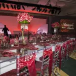 Awards dinner with long tables, burgundy accents and a lit stage