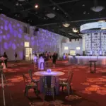 Convention reception hall with patterned gobo lighting and a central lit bar
