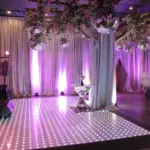 White LED dance floor with draped walls and lounge seating