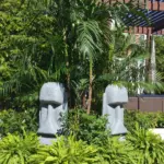 Easter Island head statues standing among ferns and tropical plants