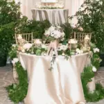 Sweetheart table surrounded by potted greenery and white florals