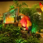Tiki totem display surrounded by palms and tropical plants with warm lighting