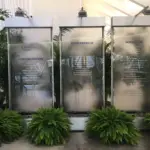 Frosted glass water wall panels surrounded by green ferns and palms
