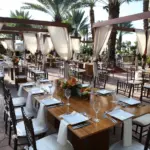 Outdoor cabana dining area with draped pergolas and wooden tables