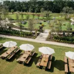 Picnic tables with white umbrellas on a landscaped garden lawn