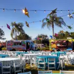 Lawn event with hanging star lanterns, palm trees and food trucks